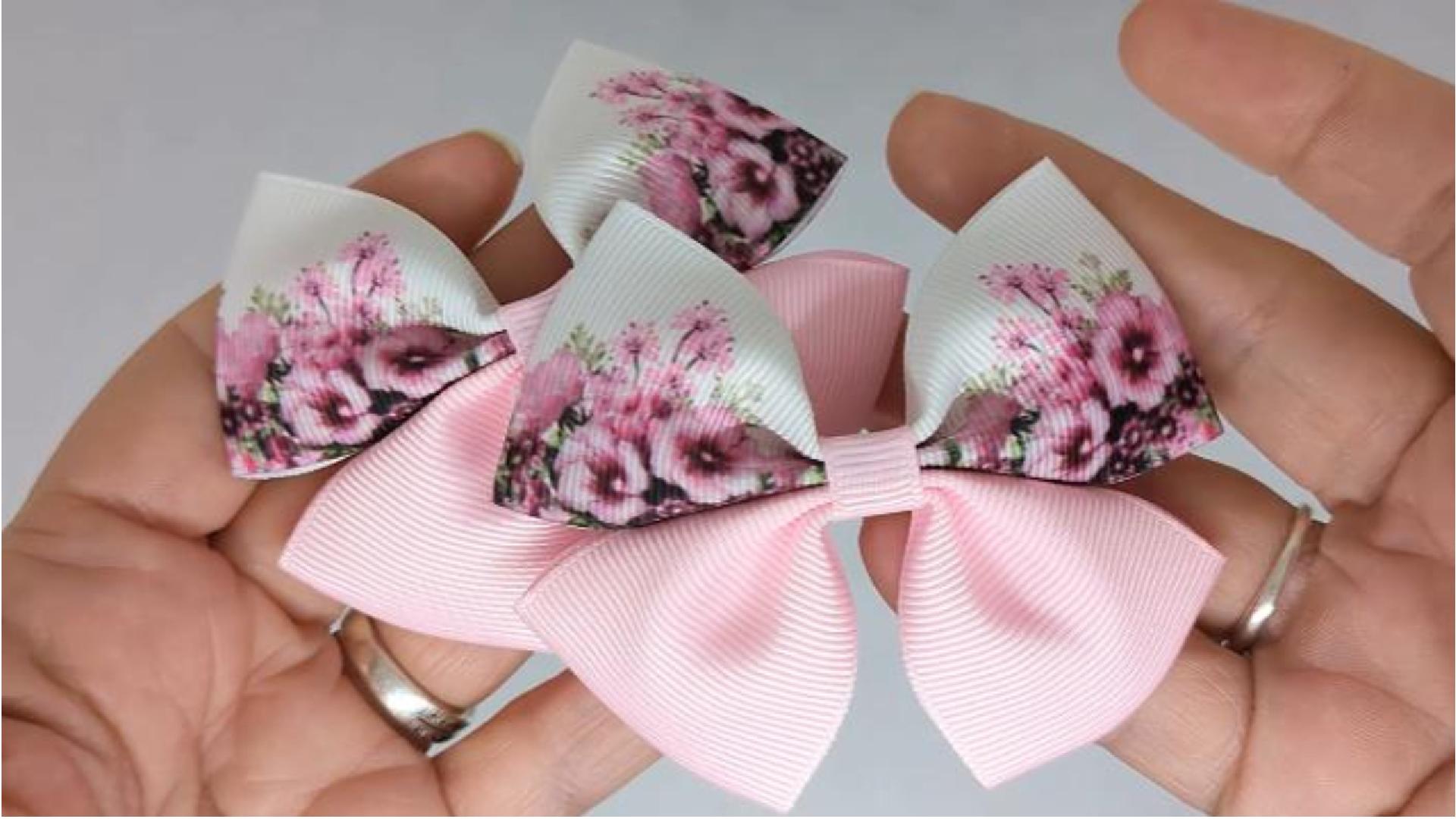 Close-up of baby pink and white floral hair bows on alligator clips, measuring 8cm x 6cm, showcasing the pretty floral design on grosgrain ribbon.