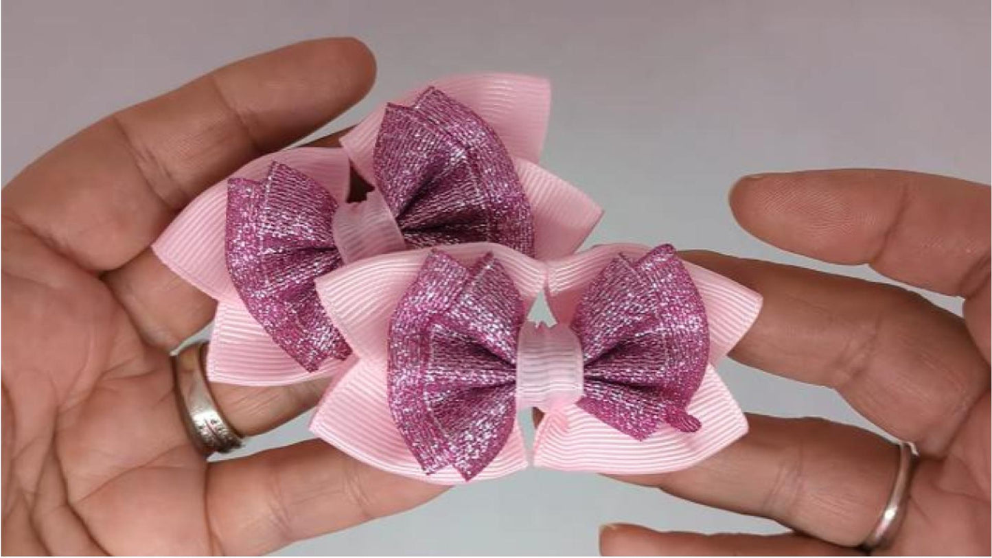 Close-up of baby pink and cerise pink glitter hair bows on alligator clips, measuring 7cm x 5cm, showcasing the sparkle of the glitter ribbon against the grosgrain.