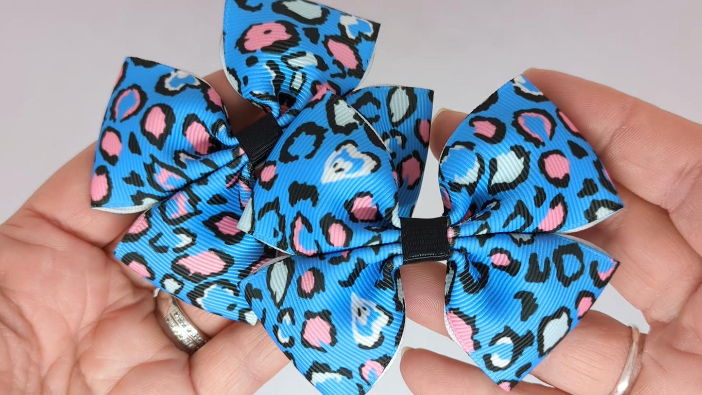 Close-up of blue leopard print hair bows on alligator clips, measuring 8cm x 6cm, showcasing the bold leopard pattern and vibrant blue colour.